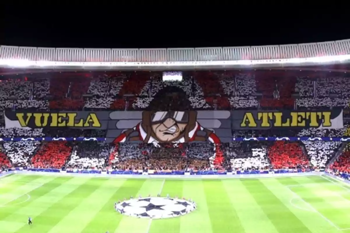 Estadio de fútbol con una coreografía de aficionados mostrando un mosaico que dice "Vuela Atleti" y una imagen de un aviador.