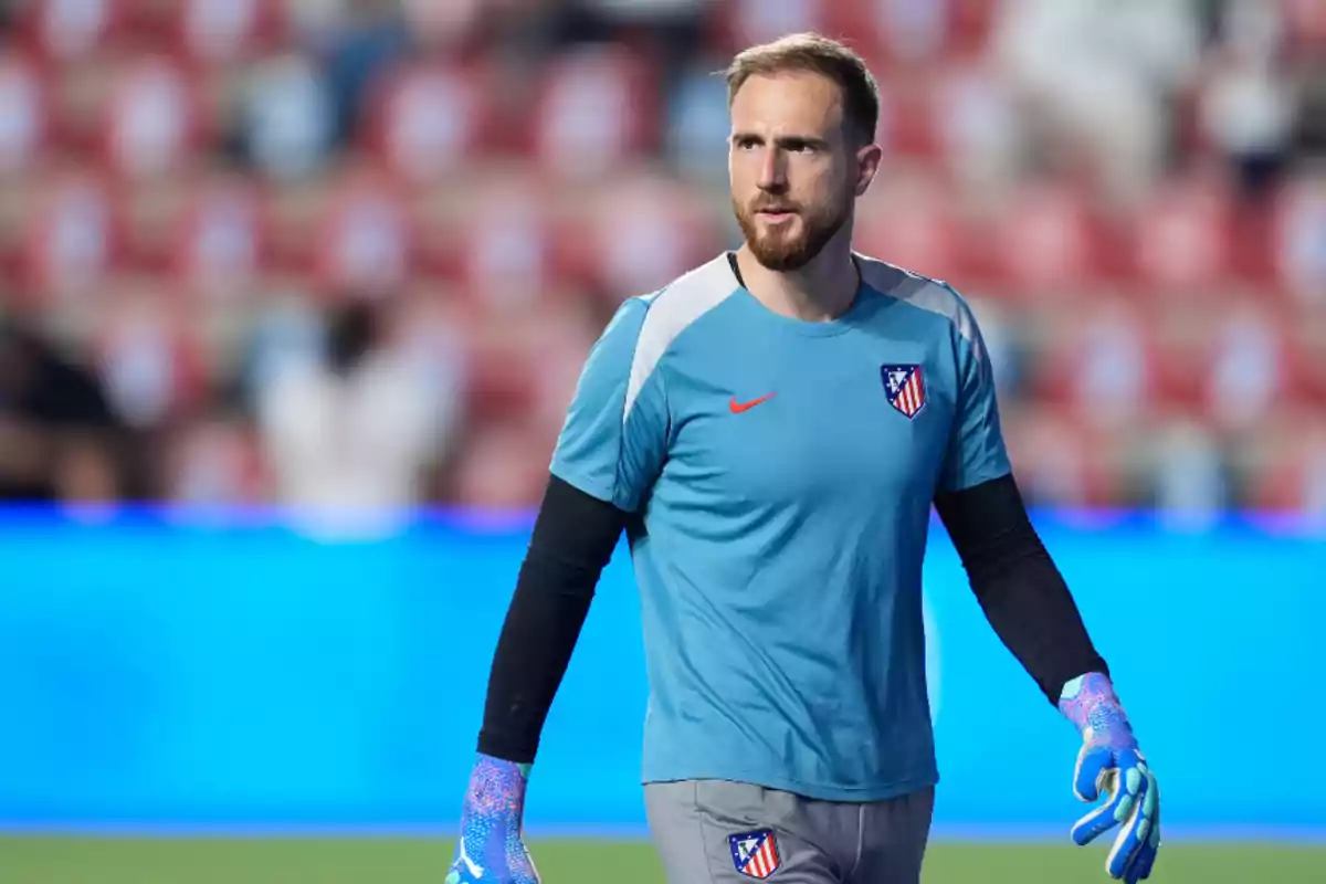 A football goalkeeper in Atlético de Madrid training uniform on the pitch.