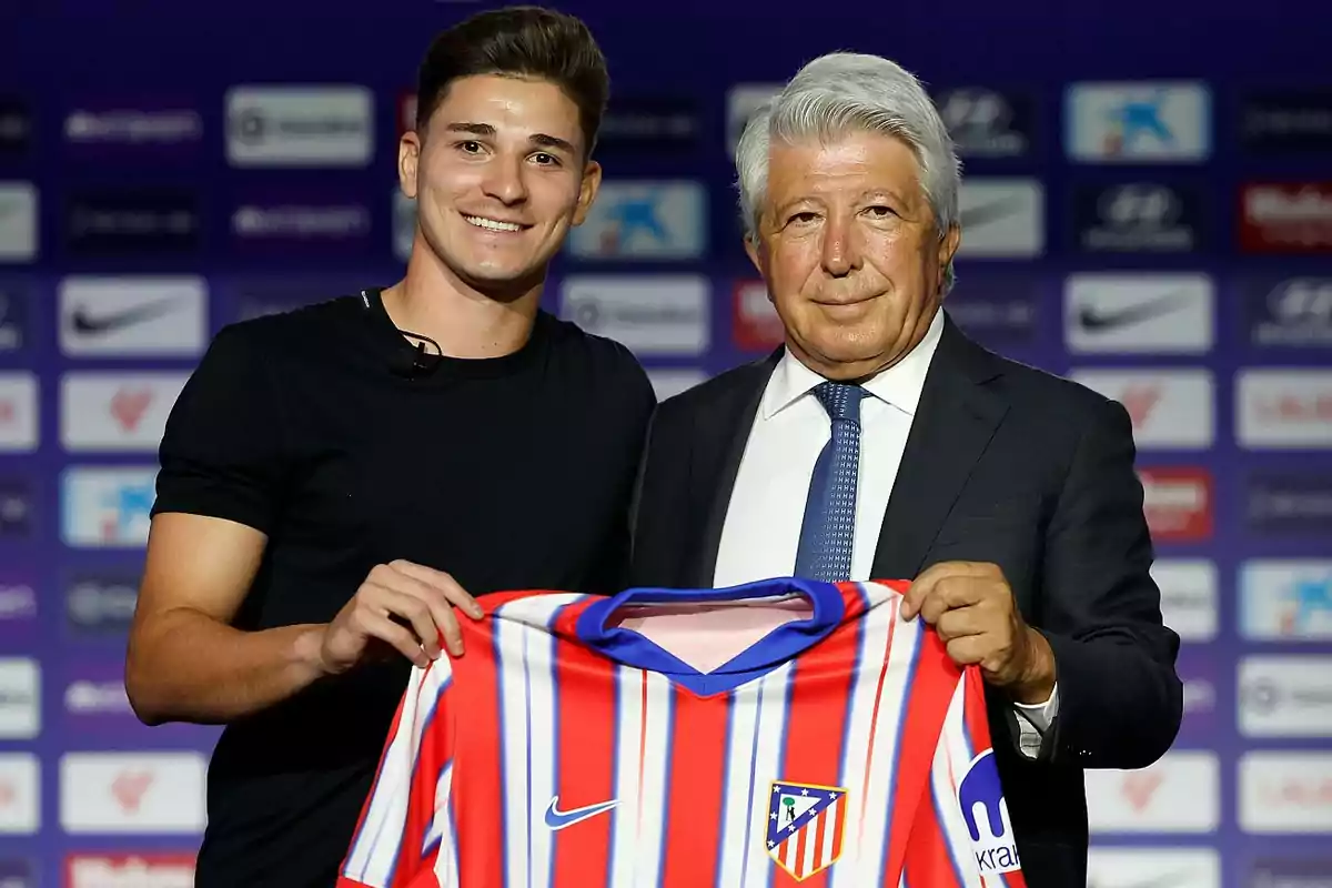 Two people pose with an Atlético de Madrid shirt at an official event. Two people pose with an Atlético de Madrid shirt at an official event.