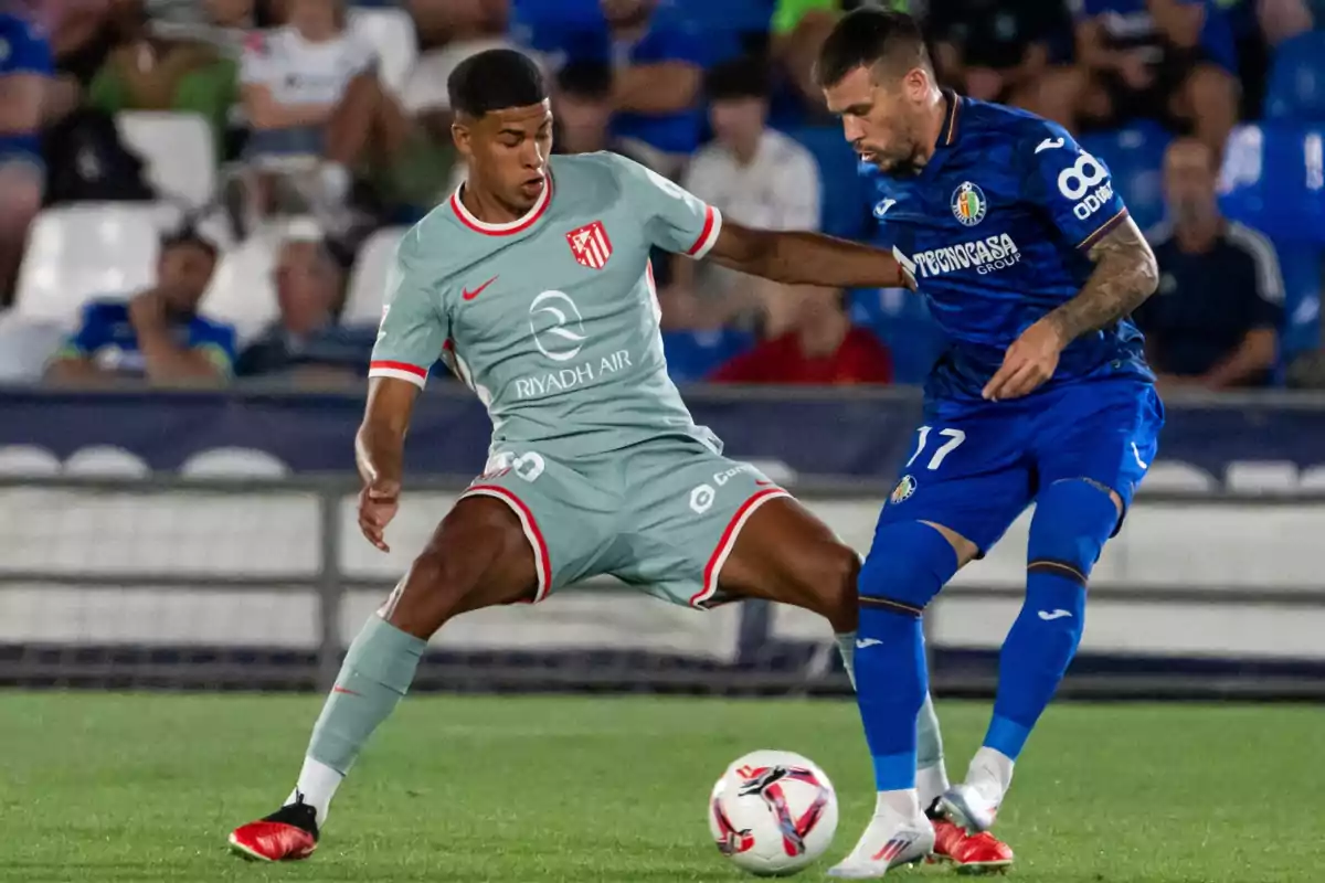 Two soccer players compete for the ball in a game.