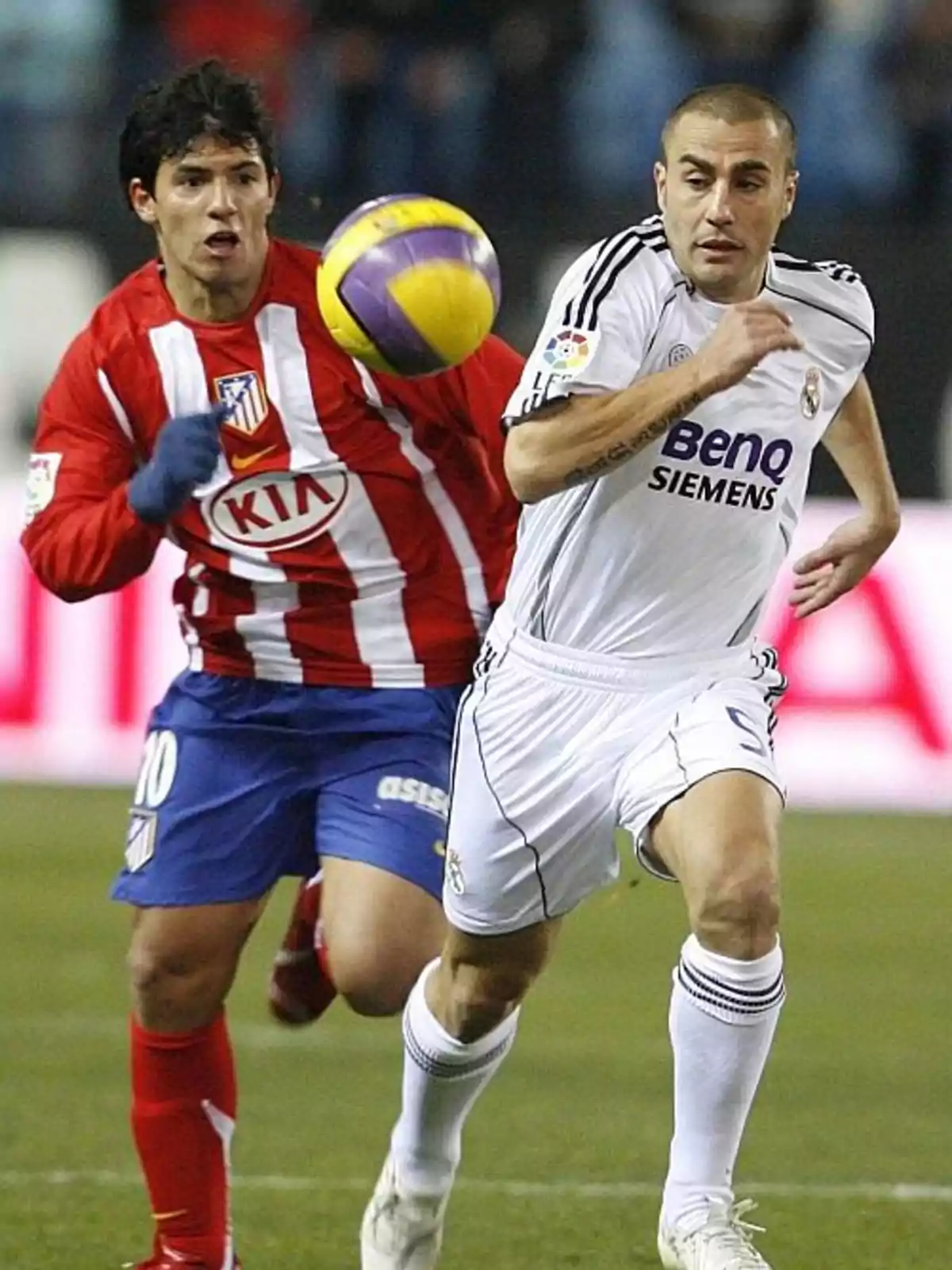Dos jugadores de fútbol compiten por el balón durante un partido entre el Atlético de Madrid y el Real Madrid.