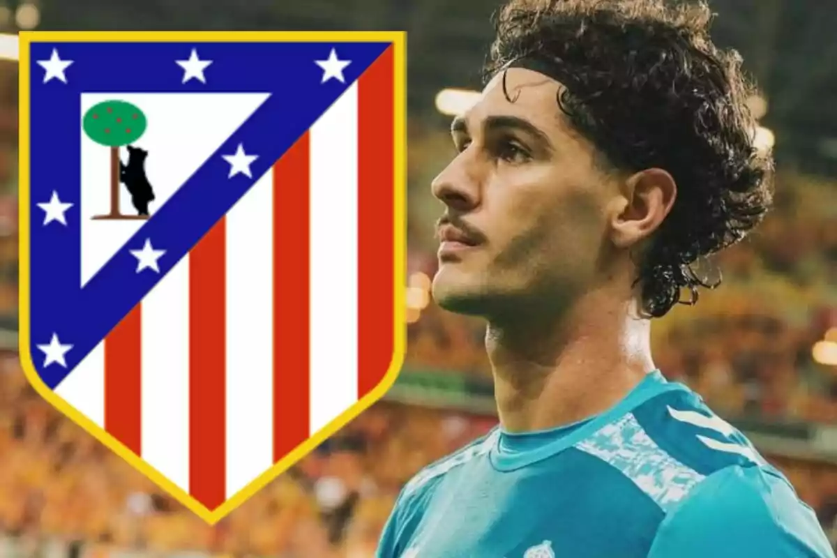 Portero de fútbol con camiseta azul junto al escudo del Atlético de Madrid