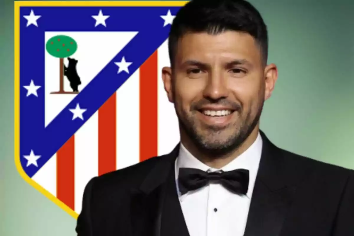 Hombre con esmoquin sonriente frente al escudo del Atlético de Madrid