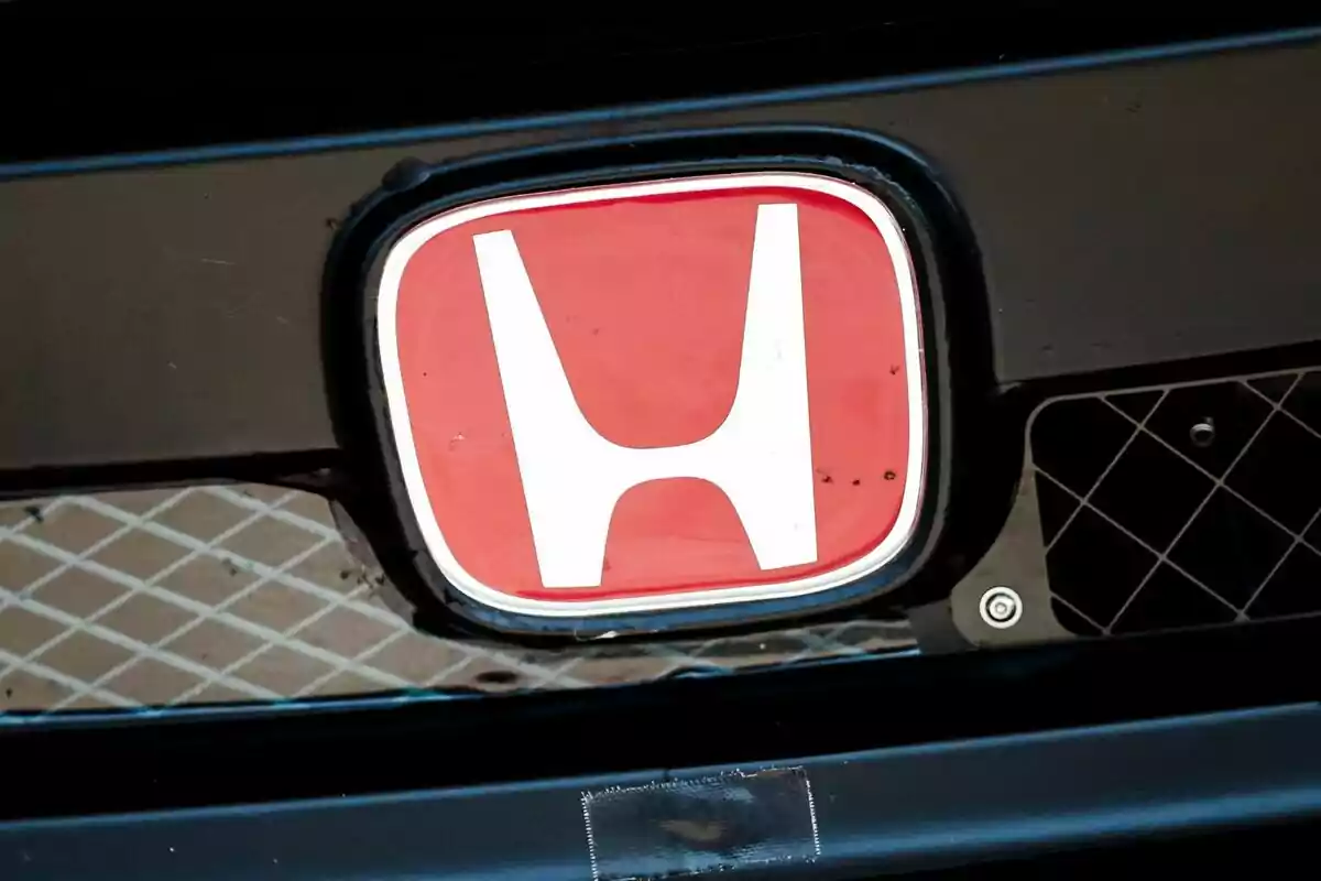 Emblema de Honda con fondo rojo en la parrilla de un automóvil negro Emblema de Honda con fondo rojo en la parrilla de un automóvil negro