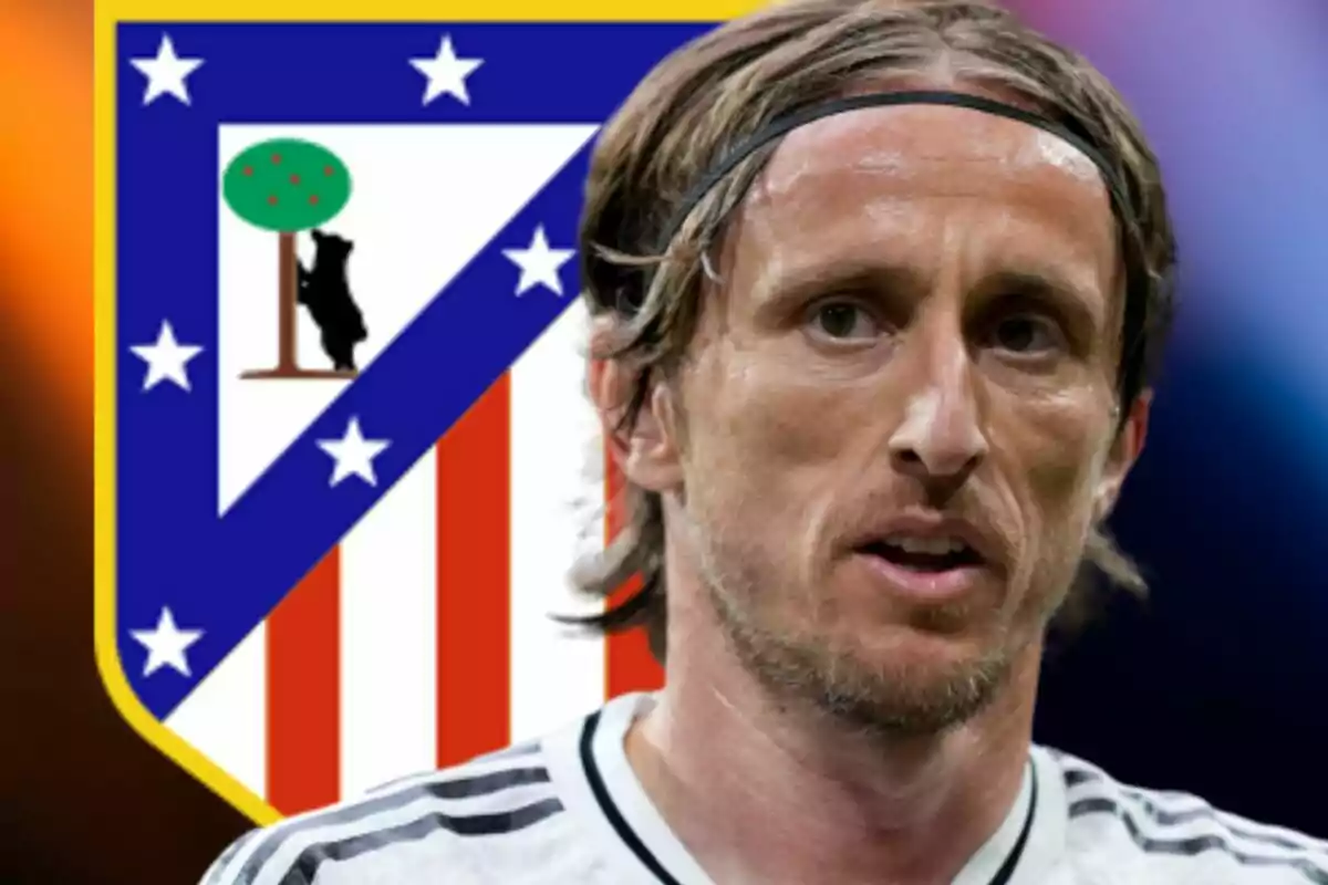 Futbolista con camiseta blanca frente al escudo del Atlético de Madrid