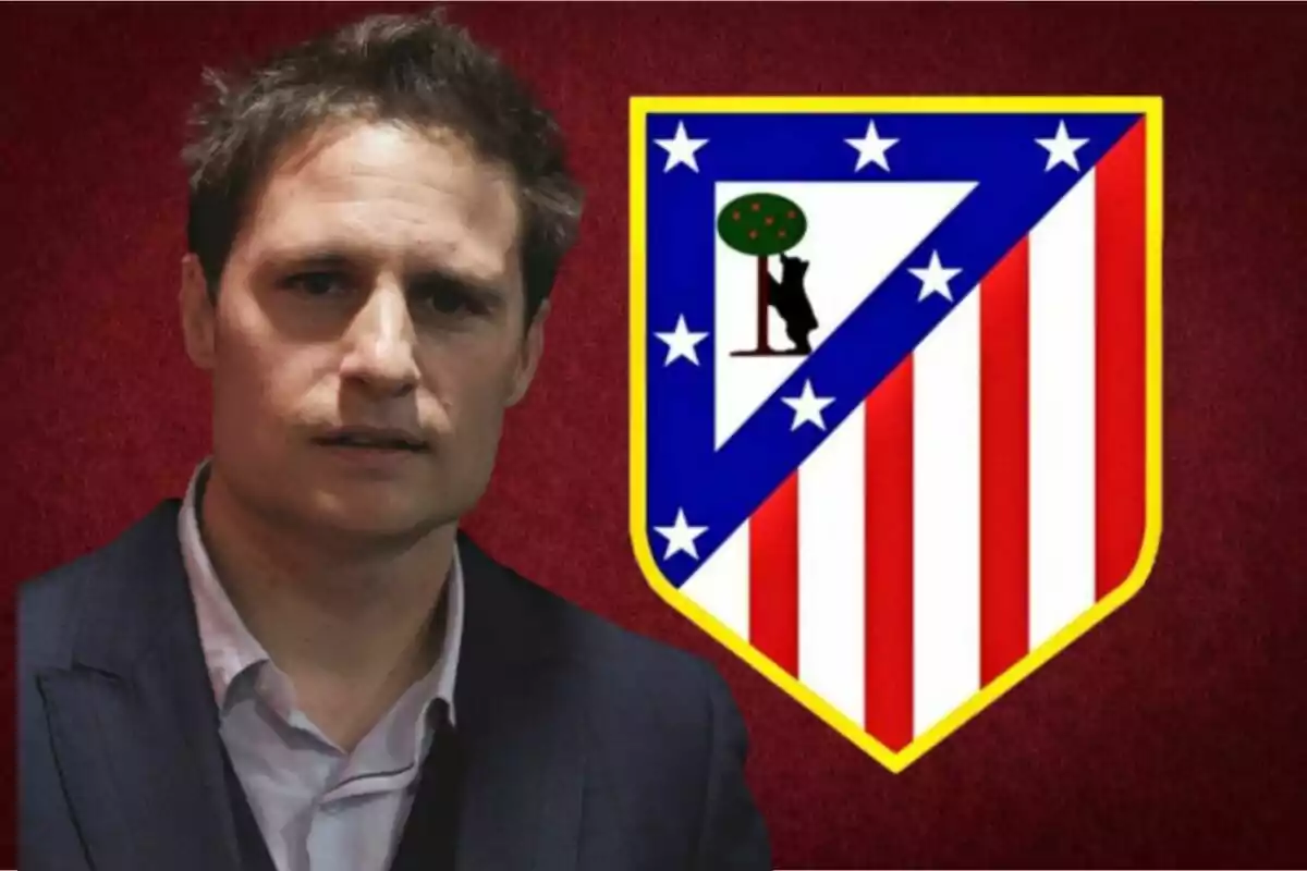Hombre de cabello corto y saco oscuro posando frente al escudo del Atlético de Madrid sobre un fondo rojo