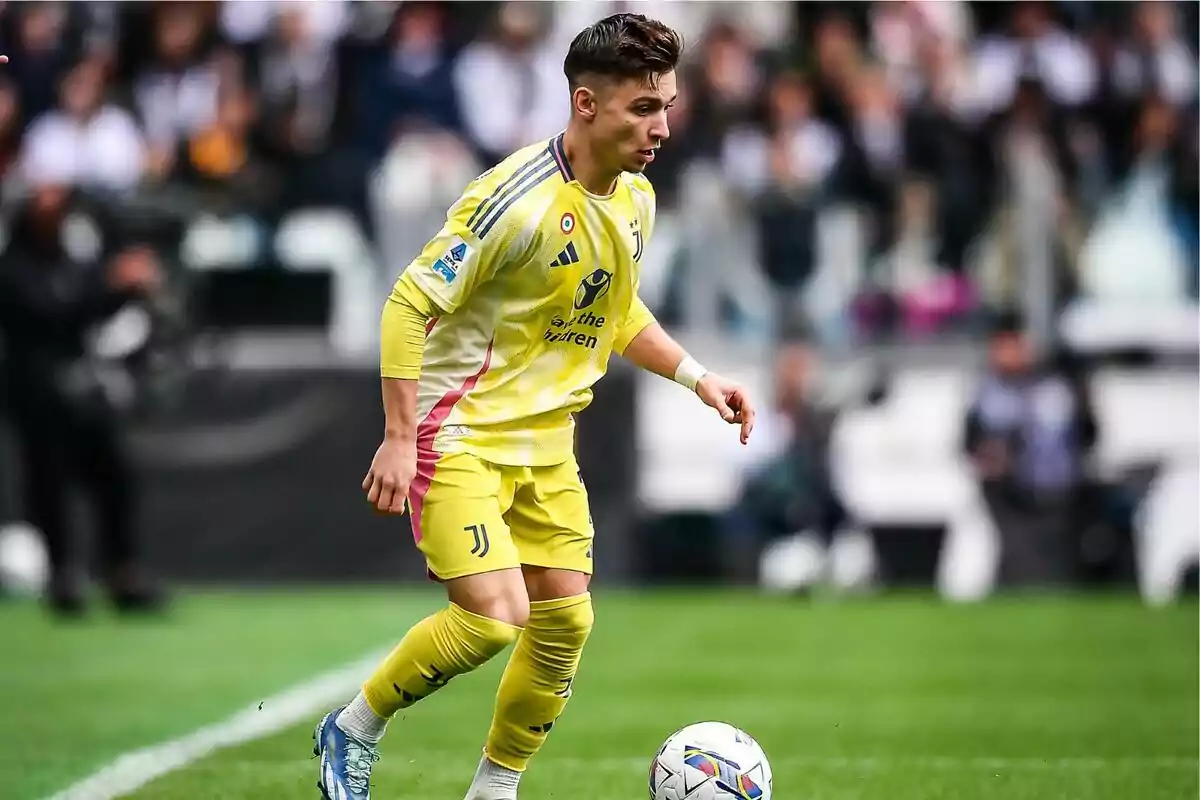 Futbolista con uniforme amarillo de la Juventus controlando el balón en un partido Futbolista con uniforme amarillo de la Juventus controlando el balón en un partido