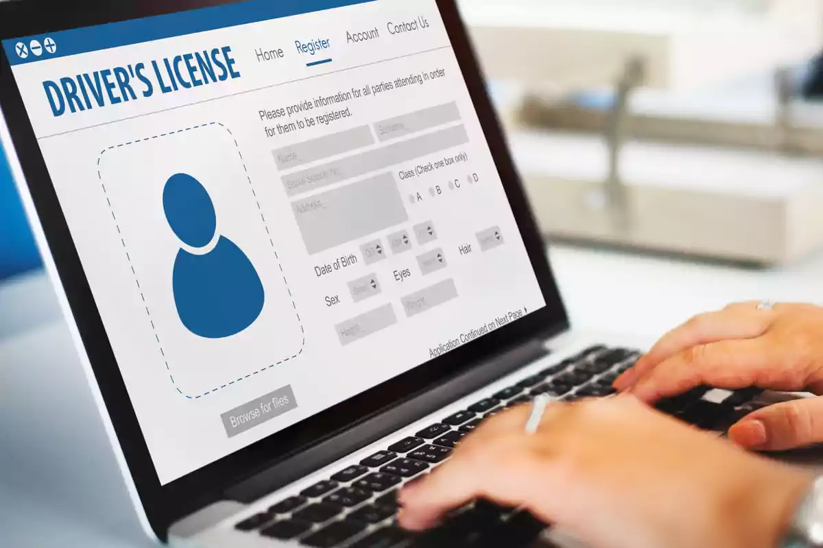 Persona usando una laptop para llenar un formulario en línea de licencia de conducir Persona usando una laptop para llenar un formulario en línea de licencia de conducir