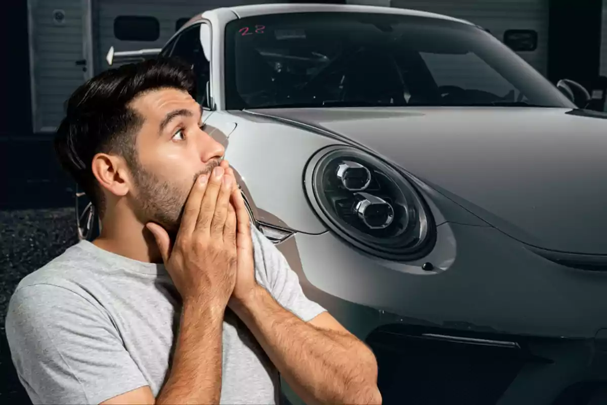 Hombre sorprendido con las manos en la boca frente a un auto deportivo gris Hombre sorprendido con las manos en la boca frente a un auto deportivo gris