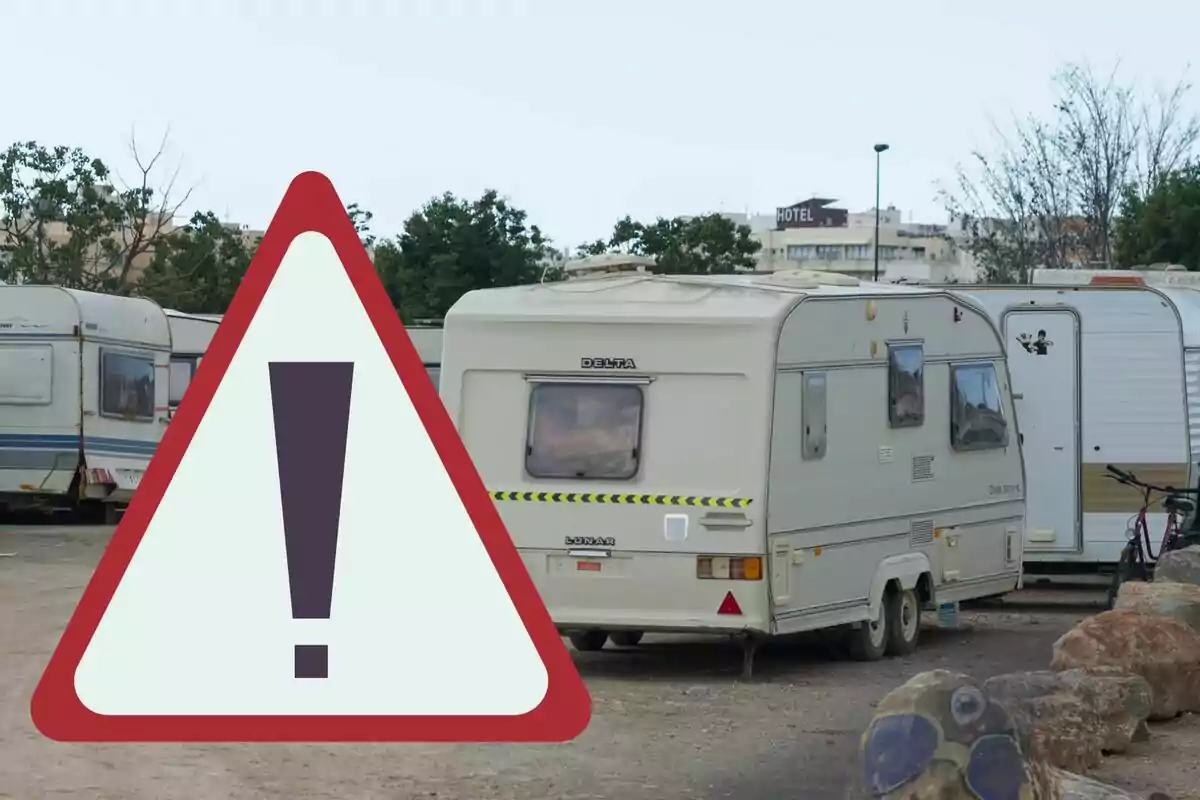 Caravans parked on a lot with a large warning sign in the foreground