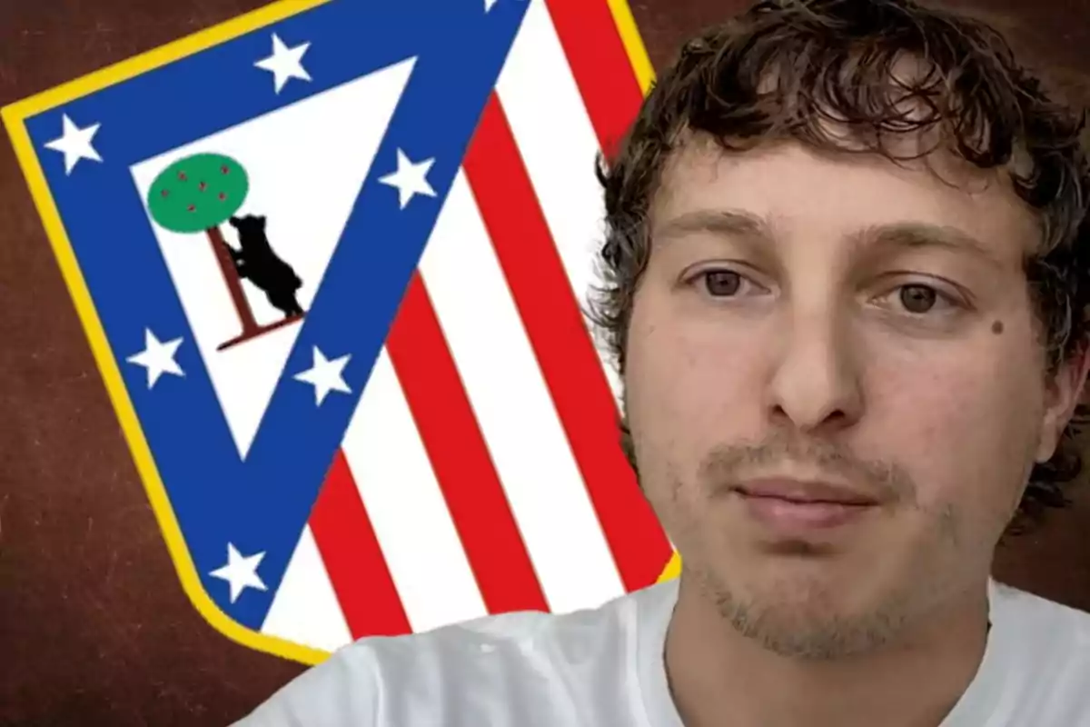 Un hombre de cabello corto y rizado aparece en primer plano con el escudo del Atlético de Madrid de fondo.