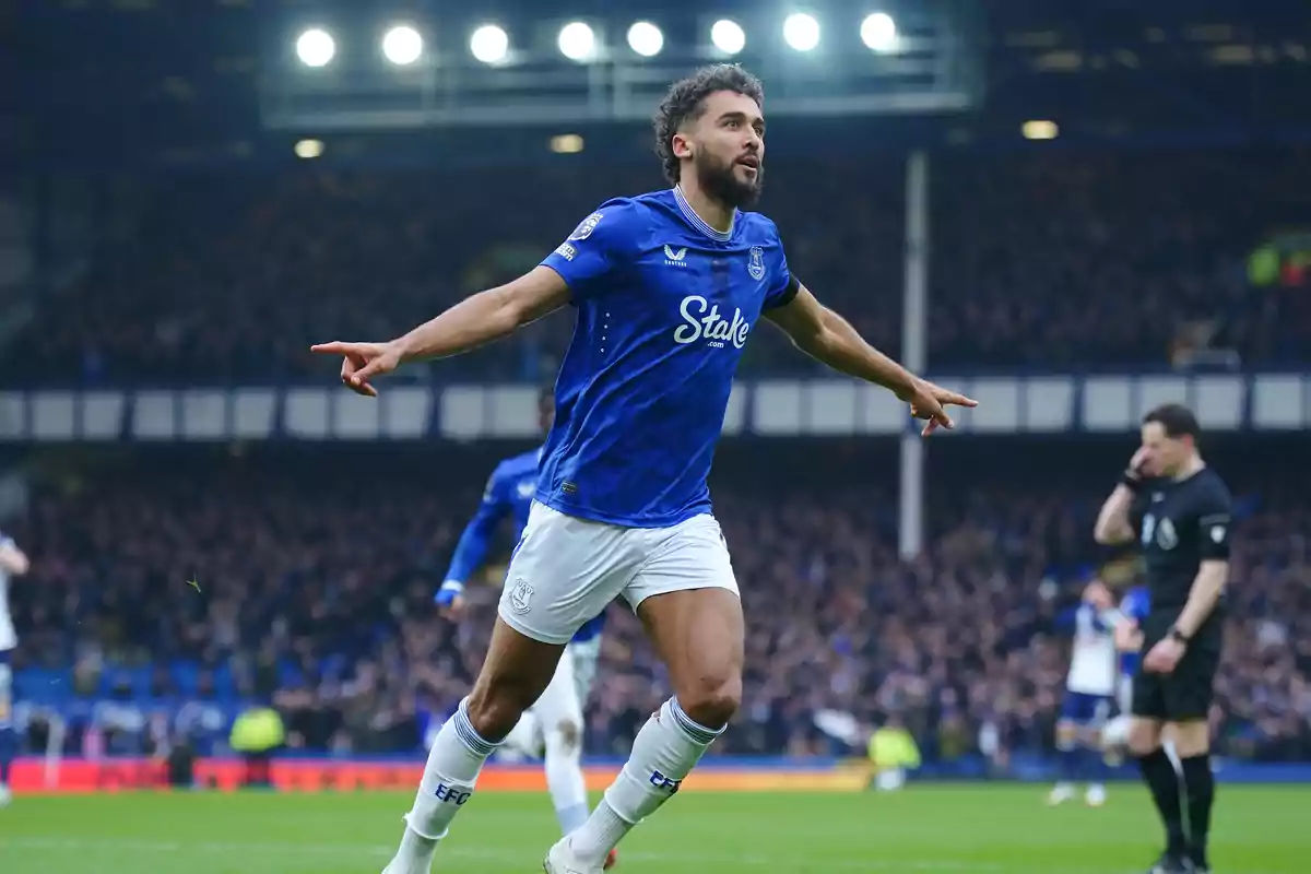 Futbolista del Everton celebrando un gol con los brazos extendidos en un estadio lleno de aficionados Futbolista del Everton celebrando un gol con los brazos extendidos en un estadio lleno de aficionados
