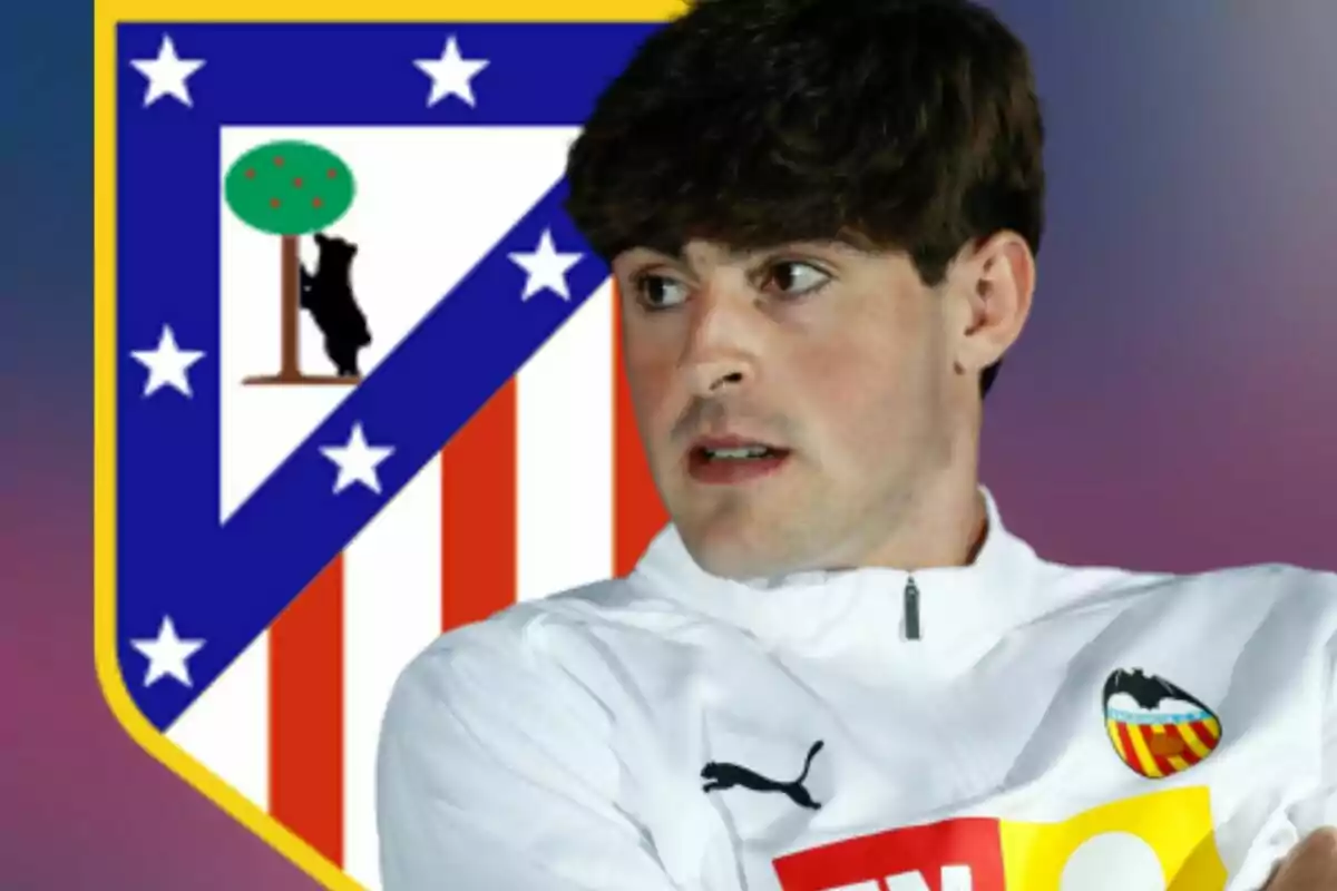 Un futbolista con chaqueta blanca del Valencia aparece frente al escudo del Atlético de Madrid