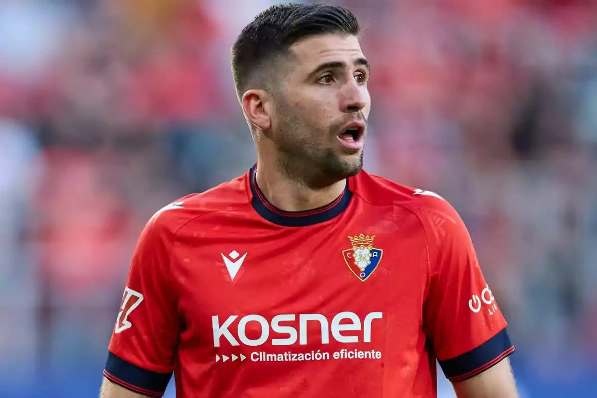 Futbolista con camiseta roja del Club Atlético Osasuna durante un partido Futbolista con camiseta roja del Club Atlético Osasuna durante un partido