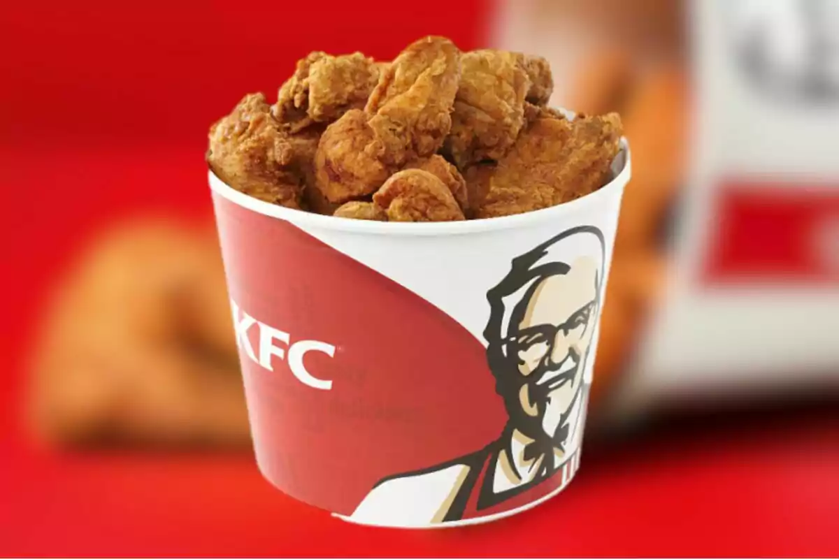 Cubeta de pollo frito de KFC sobre fondo rojo Cubeta de pollo frito de KFC sobre fondo rojo