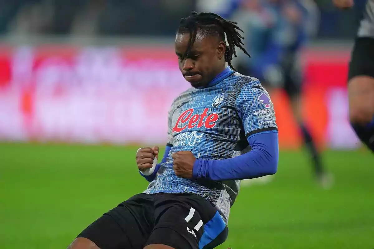 Futbolista celebrando un gol arrodillado sobre el césped con el uniforme azul y negro del Atalanta Futbolista celebrando un gol arrodillado sobre el césped con el uniforme azul y negro del Atalanta