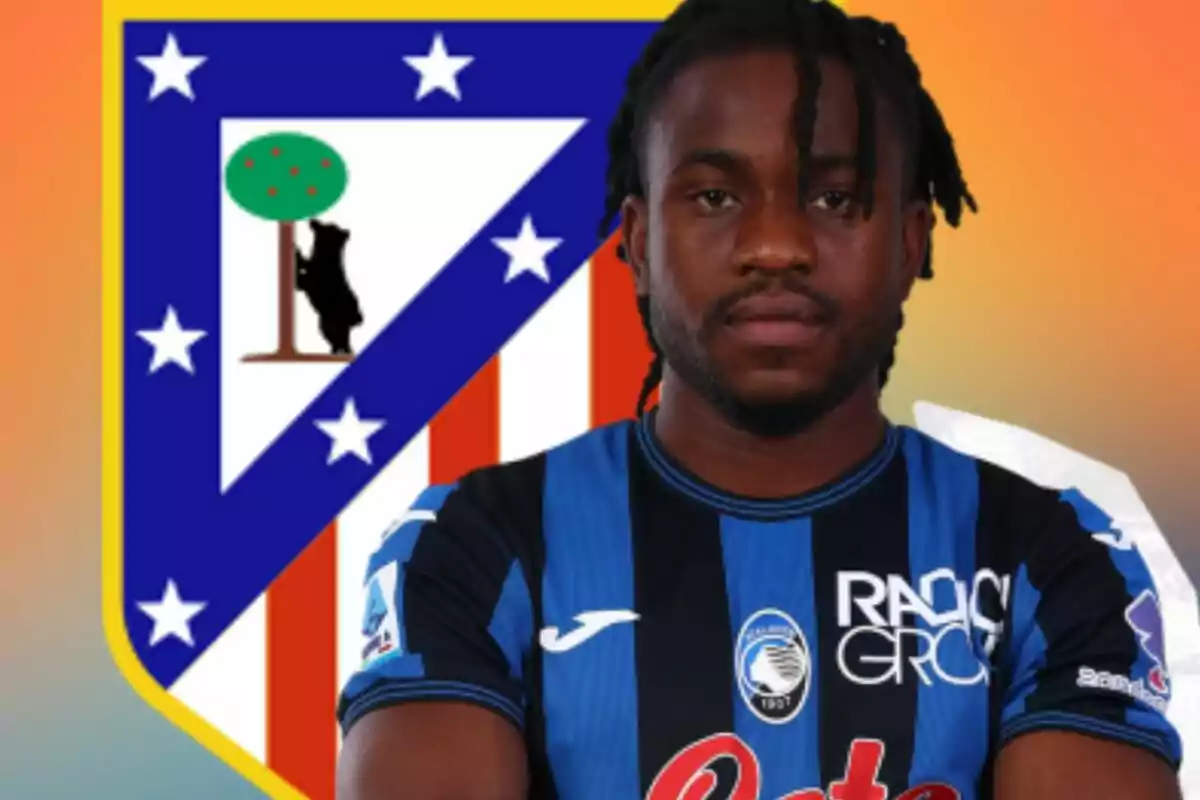 Futbolista con uniforme azul y negro posando frente al escudo del Atlético de Madrid sobre un fondo degradado naranja.