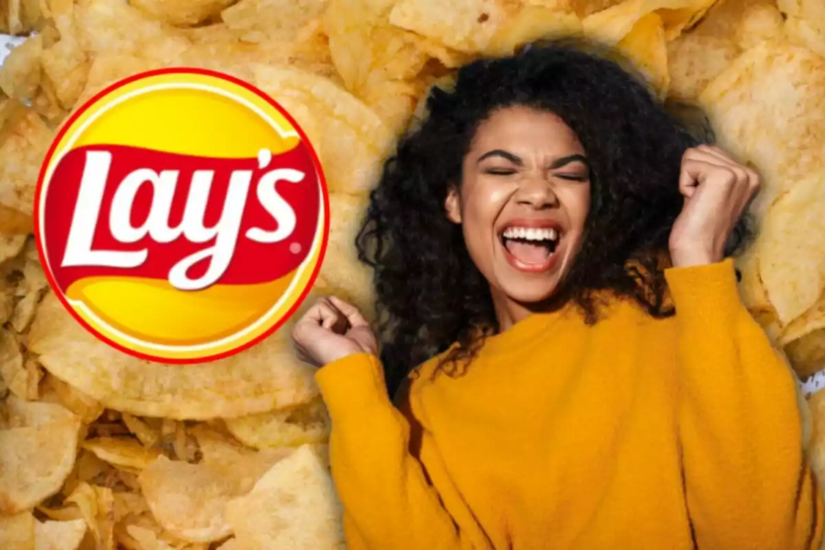 Smiling woman in a yellow sweater celebrating next to the Lay's logo against a background of potato chips
