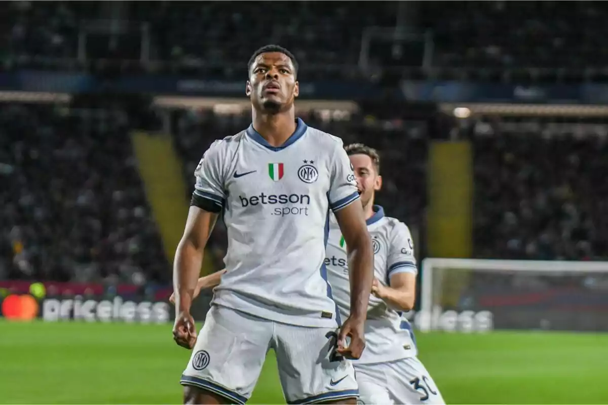 Futbolista del Inter de Milán celebrando un gol en el campo con un compañero detrás y el estadio de fondo Futbolista del Inter de Milán celebrando un gol en el campo con un compañero detrás y el estadio de fondo