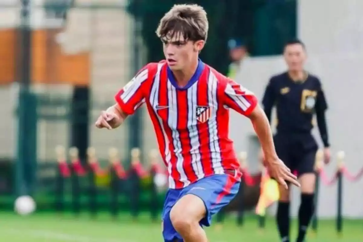 Joven futbolista con uniforme del Atlético de Madrid corriendo en un partido de fútbol Joven futbolista con uniforme del Atlético de Madrid corriendo en un partido de fútbol