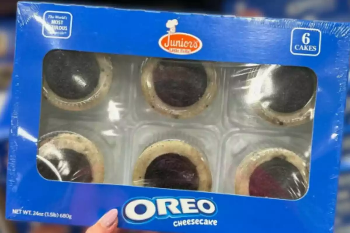 Caja azul de seis mini cheesecakes de Oreo de la marca Junior's sostenida por una mano Caja azul de seis mini cheesecakes de Oreo de la marca Junior's sostenida por una mano