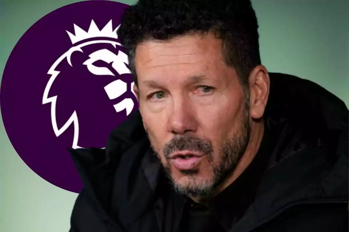Entrenador de fútbol con chaqueta oscura en primer plano y el logo de la Premier League al fondo
