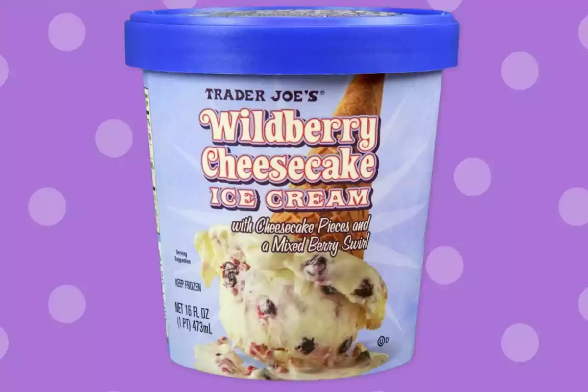 Envase de helado Trader Joe's sabor Wildberry Cheesecake sobre un fondo morado con lunares blancos Envase de helado Trader Joe's sabor Wildberry Cheesecake sobre un fondo morado con lunares blancos