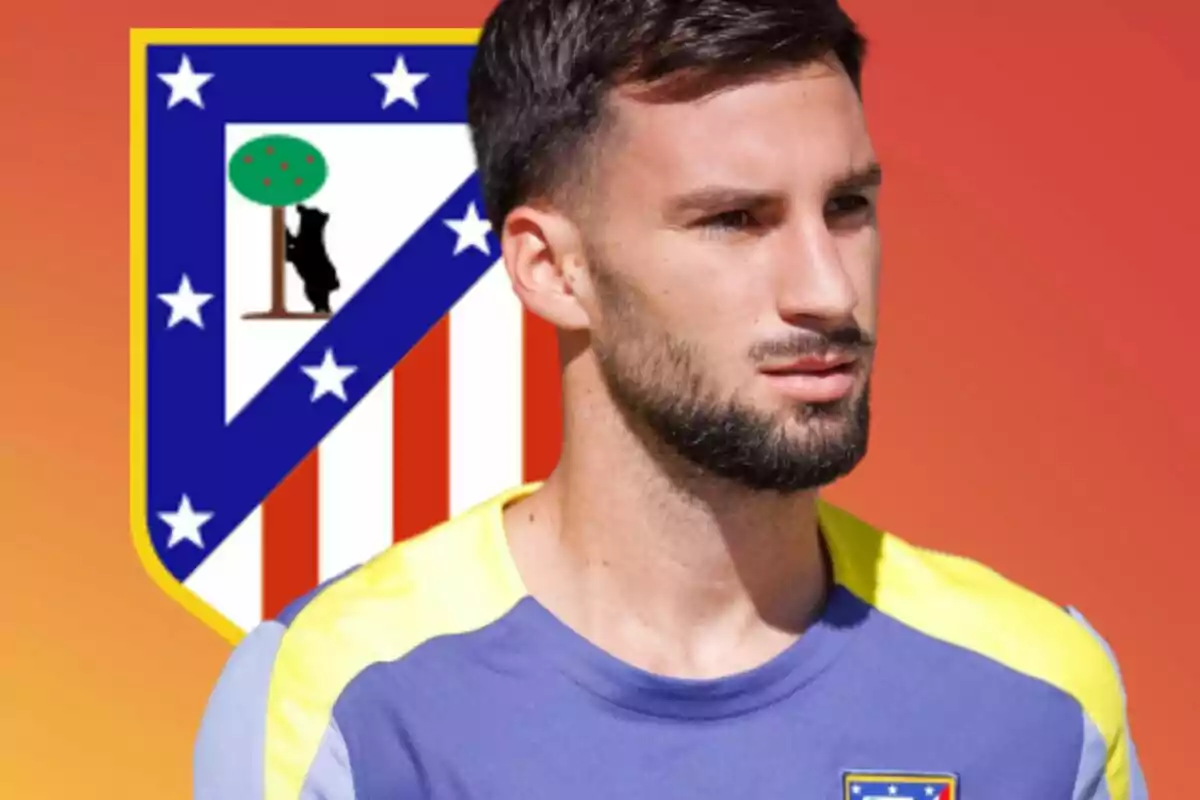Jugador de fútbol con camiseta de entrenamiento del Atlético de Madrid posando frente al escudo del club sobre un fondo degradado naranja