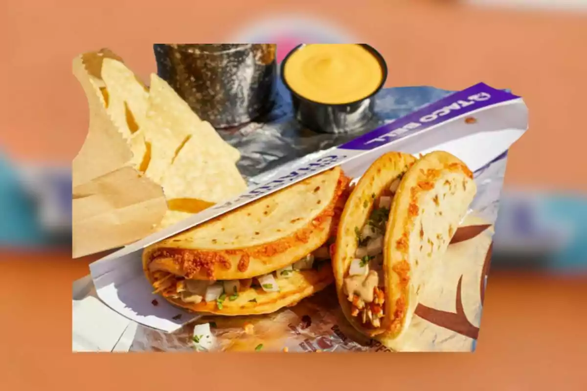 Dos tacos con tortillas doradas y relleno de pollo acompañados de totopos y salsa de queso en un recipiente pequeño Dos tacos con tortillas doradas y relleno de pollo acompañados de totopos y salsa de queso en un recipiente pequeño