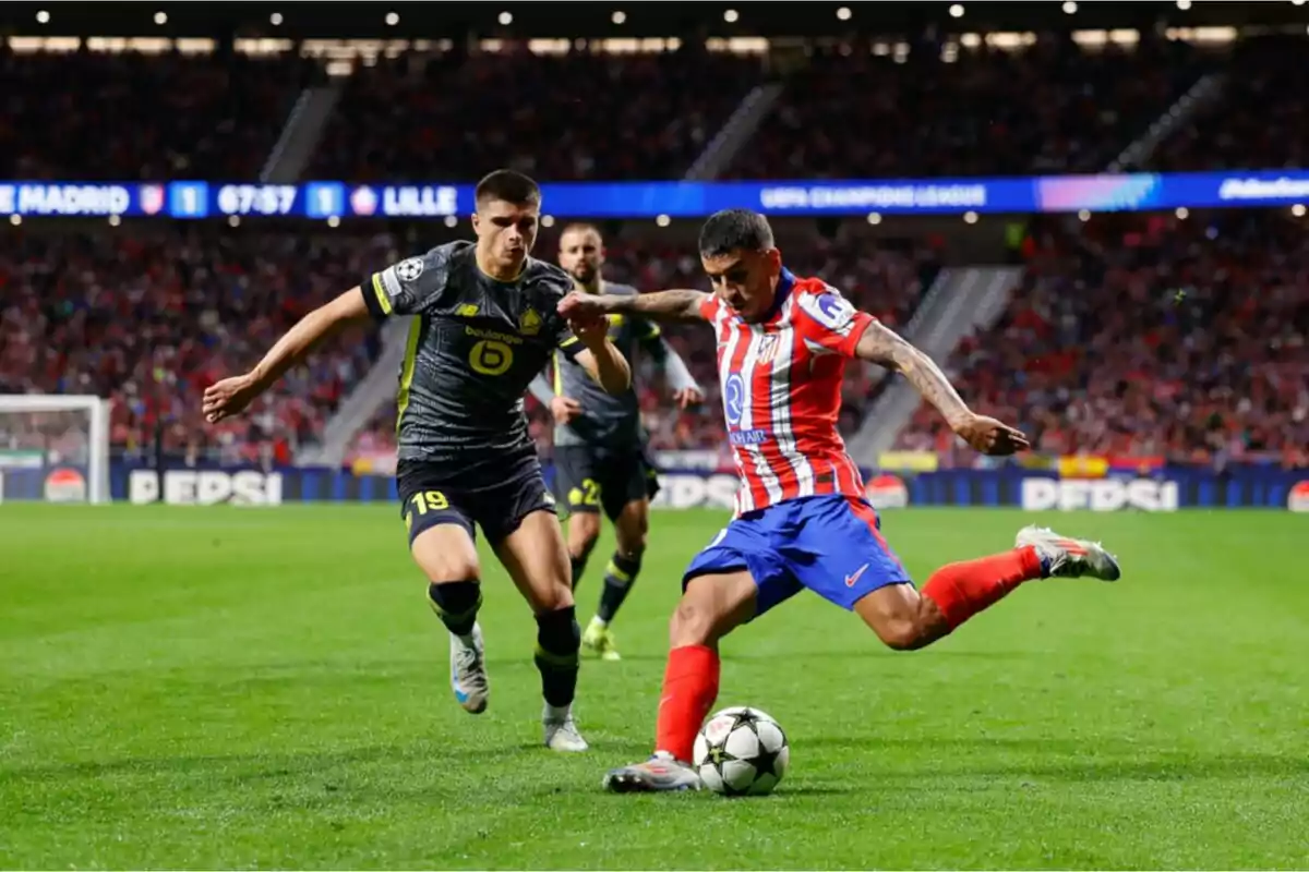 Dos futbolistas disputan el balón durante un partido de la Champions League en un estadio lleno de espectadores Dos futbolistas disputan el balón durante un partido de la Champions League en un estadio lleno de espectadores