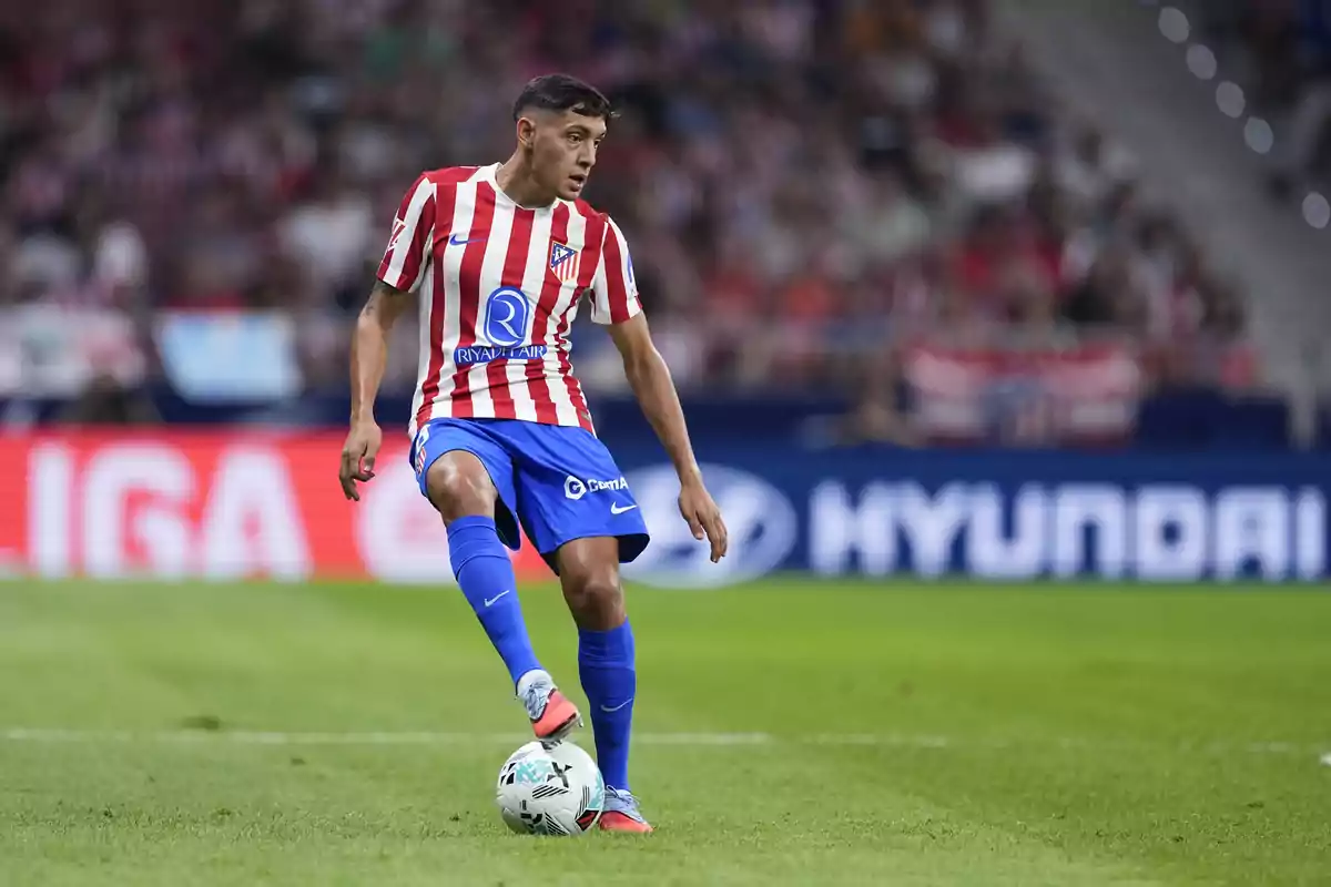 Futbolista del Atlético de Madrid controlando el balón durante un partido en el estadio Futbolista del Atlético de Madrid controlando el balón durante un partido en el estadio
