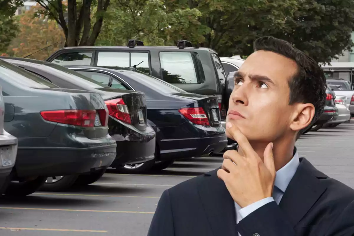 Hombre pensativo en un estacionamiento lleno de autos Hombre pensativo en un estacionamiento lleno de autos