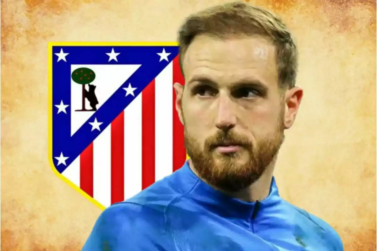 Portero con barba y uniforme azul frente al escudo del Atlético de Madrid sobre un fondo beige