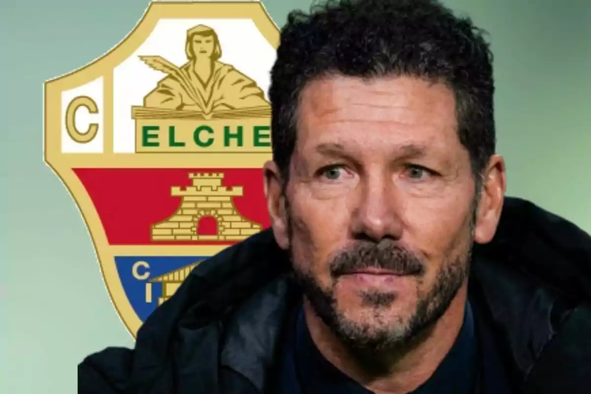 Hombre de cabello rizado y barba frente al escudo del club Elche