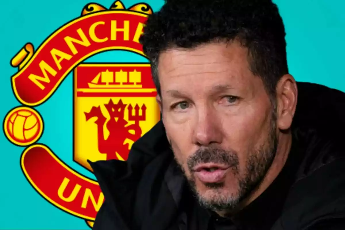 Un hombre de cabello rizado y barba aparece en primer plano con el escudo del Manchester United de fondo