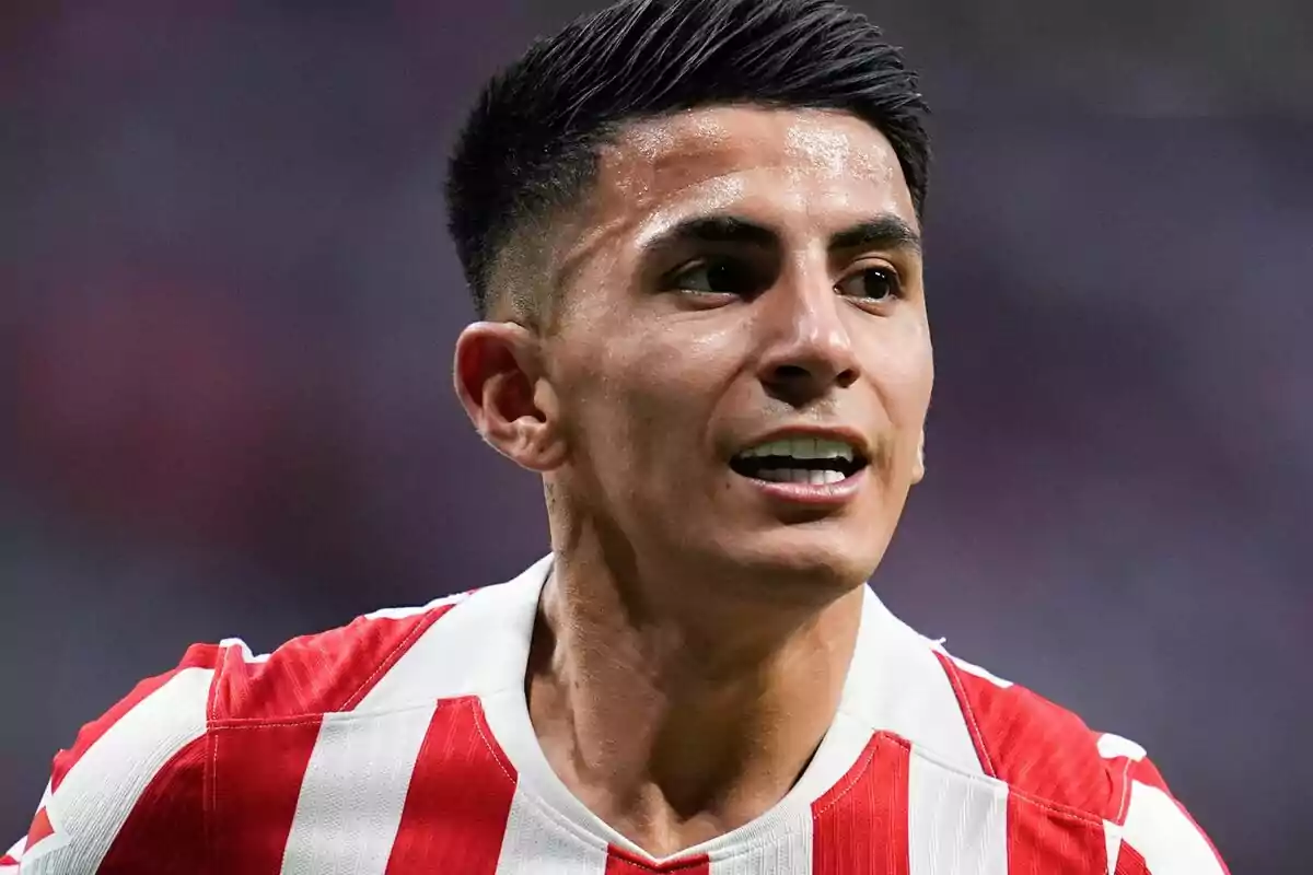Jugador de fútbol con uniforme de rayas rojas y blancas durante un partido