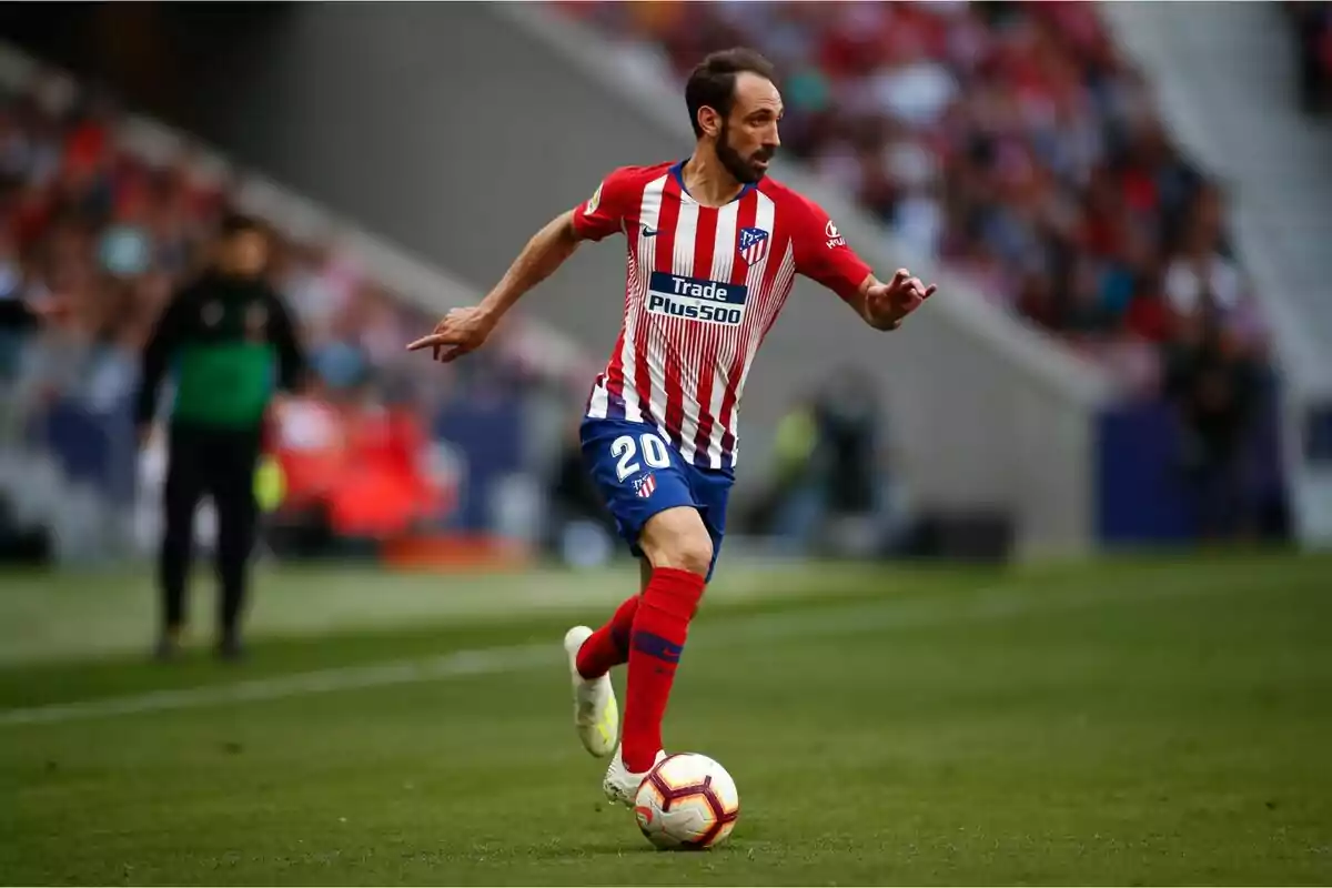 Futbolista del Atlético de Madrid controlando el balón durante un partido en el estadio Futbolista del Atlético de Madrid controlando el balón durante un partido en el estadio
