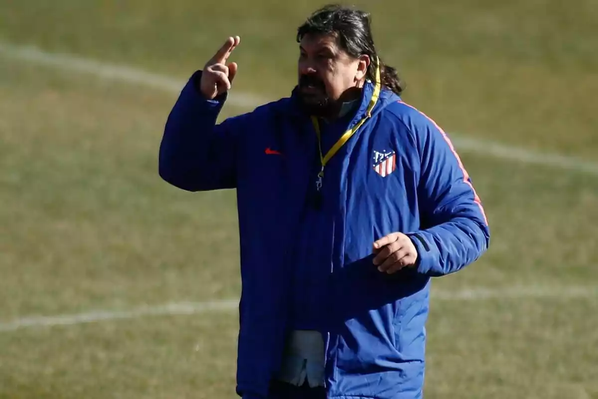 Entrenador con chaqueta azul del Atlético de Madrid dando indicaciones en un campo de fútbol Entrenador con chaqueta azul del Atlético de Madrid dando indicaciones en un campo de fútbol