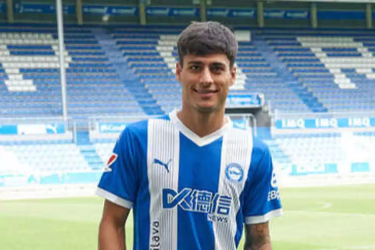 A soccer player in a blue and white uniform in a stadium.