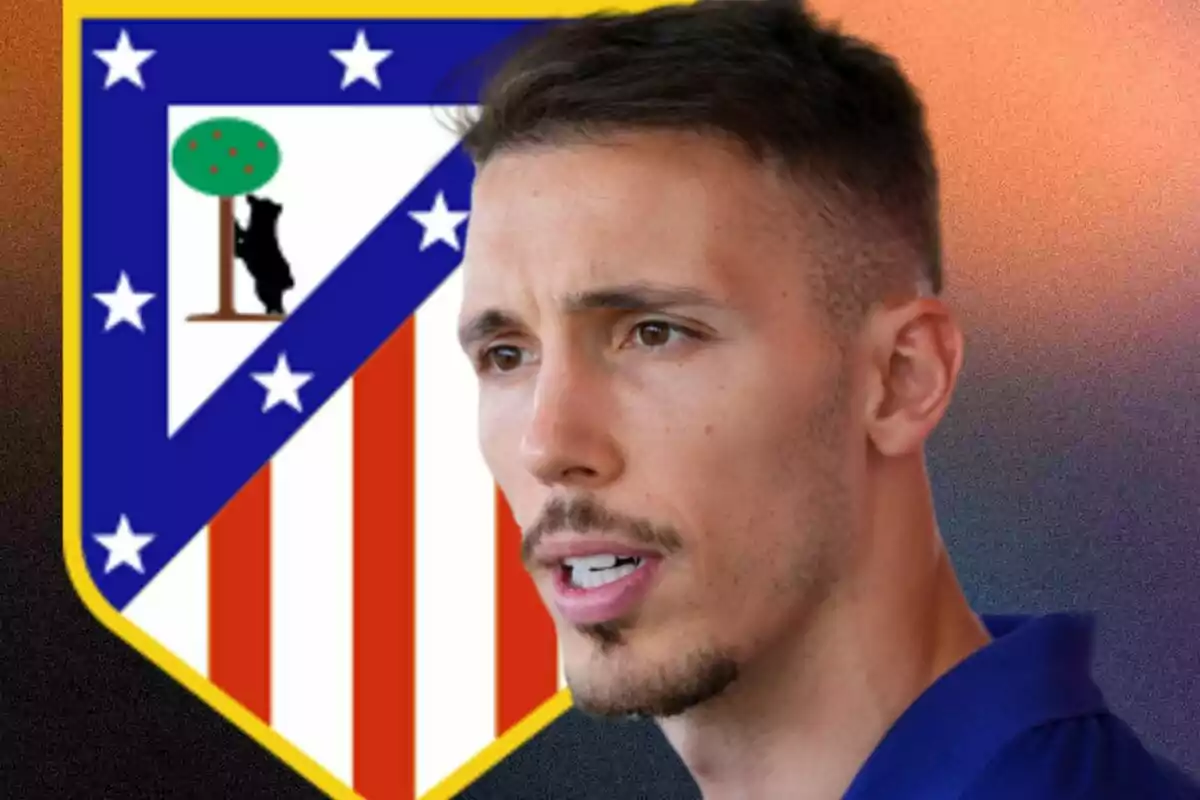 Hombre de cabello corto y barba recortada con el escudo del Atlético de Madrid de fondo