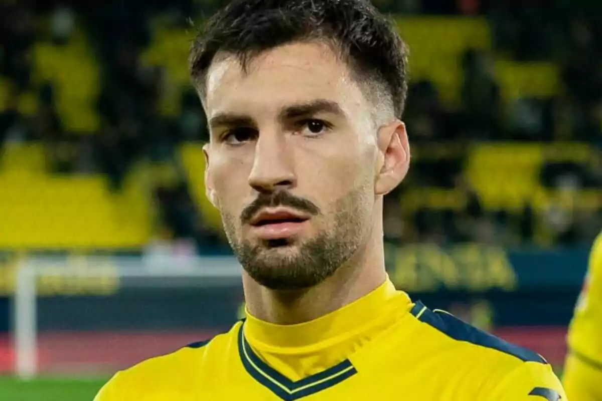 Un jugador de fútbol con uniforme amarillo en un estadio.