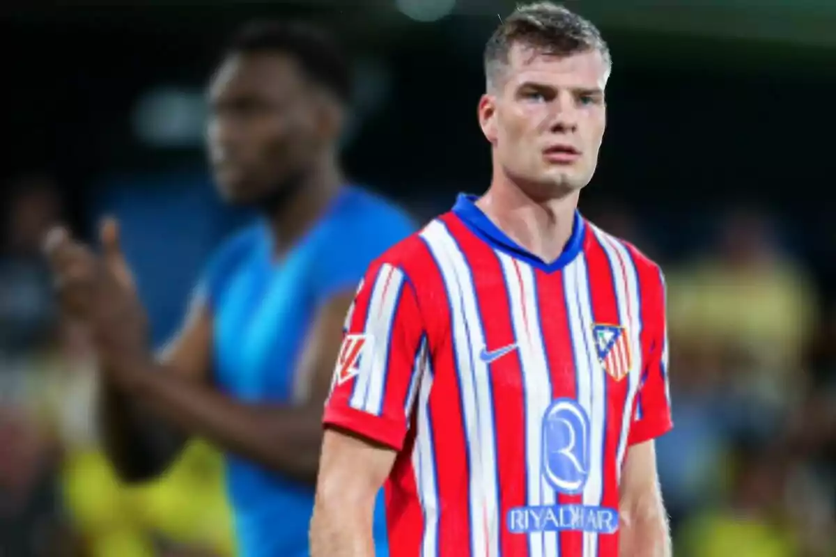 Un jugador de fútbol con la camiseta del Atlético de Madrid en un campo de fútbol.