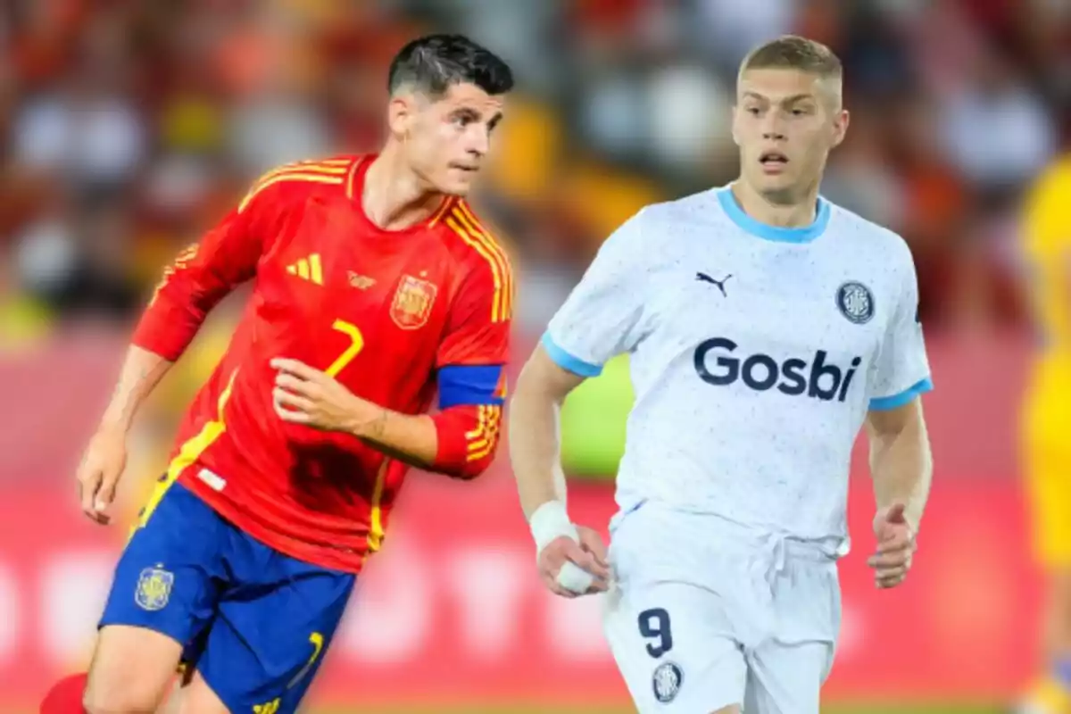 Dos jugadores de fútbol en el campo, uno con el uniforme rojo de la selección española y el otro con el uniforme blanco de un club deportivo.