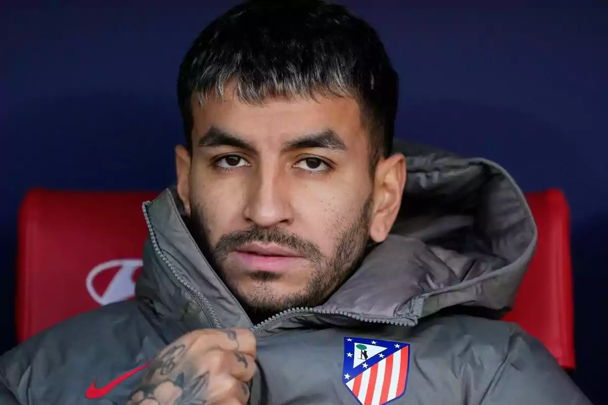 Un hombre con chaqueta gris y escudo del Atlético de Madrid.