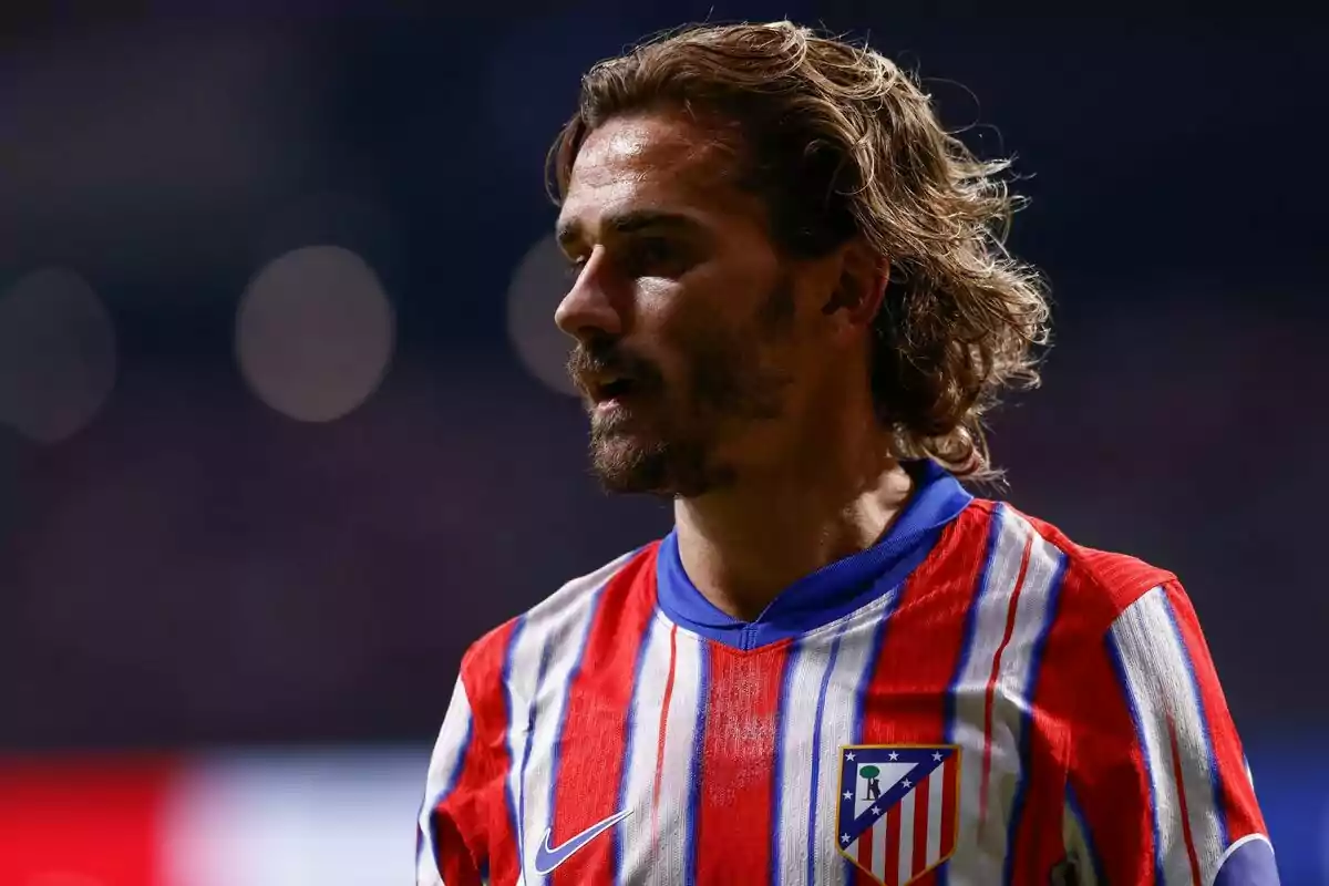 Jugador de fútbol con camiseta del Atlético de Madrid en un estadio.