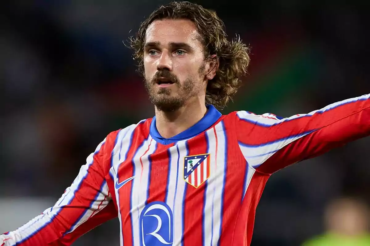 Un jugador de fútbol con el uniforme del Atlético de Madrid en el campo.