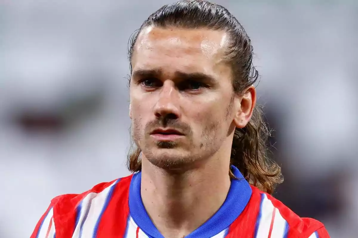 A player in a red and white striped jersey with a blurred background.