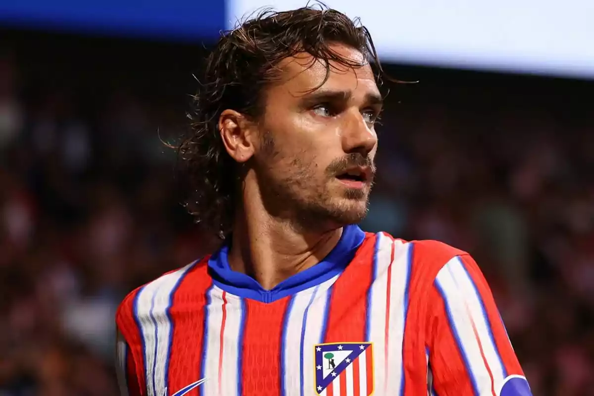 Un jugador de fútbol con la camiseta del Atlético de Madrid mirando hacia un lado.