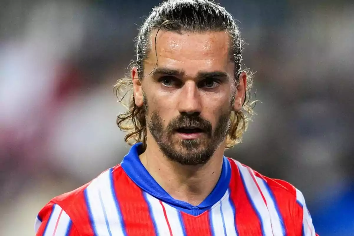 Un jugador de fútbol con camiseta de rayas rojas y blancas y cabello largo.