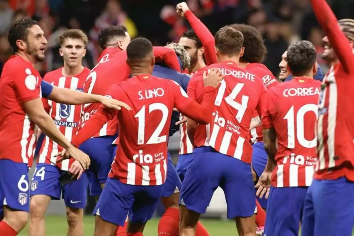 Jugadores de fútbol del Atlético de Madrid celebrando un gol en el campo.